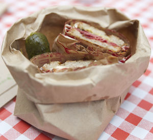 High angle view of sandwiches and pickled cucumber on table