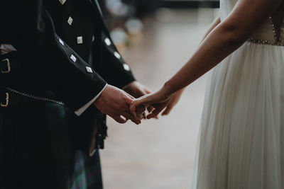 Midsection of couple holding hands