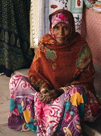 Portrait of woman wearing sari with blanket sitting at home