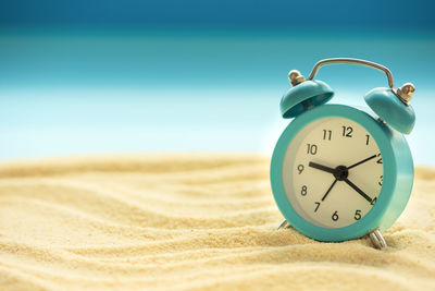 Close-up of clock on the beach