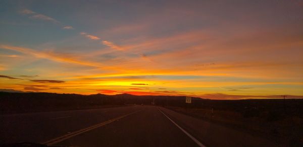 Empty road against sky during sunset