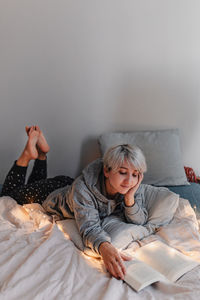 Woman lying on bed at home