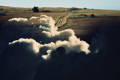 Surreal scenic view of land with empty road against sky