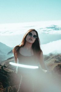 Portrait of smiling young woman against sky