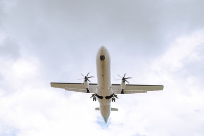 Low angle view of airplane flying against sky