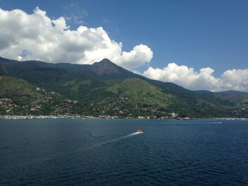 Scenic view of sea and mountains against sky