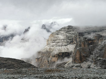 Clouds emitting from dolomites mountain against sky
