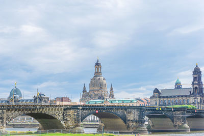 Bridge over river against buildings in city