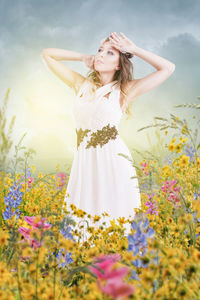 Woman standing by flowers on field