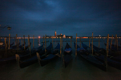 Gondolas on grand canal in city at night