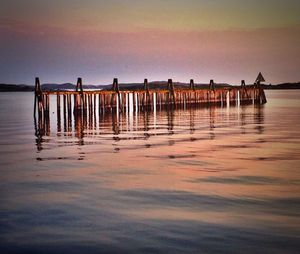 Pier on sea at sunset