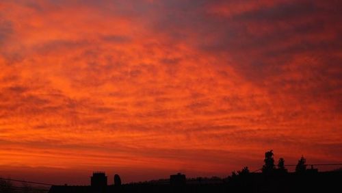 Silhouette buildings against orange sky