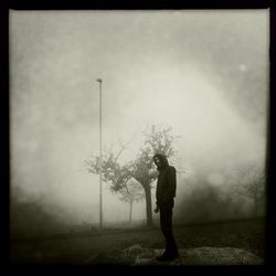 Silhouette of woman standing against trees