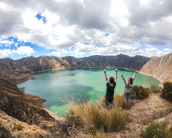 People standing on mountain against sky