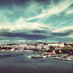 Buildings in city against cloudy sky