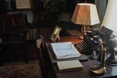 High angle view of books with vintage telephone and typewriter on table