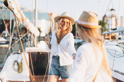 Young woman wearing sunglasses standing on boat