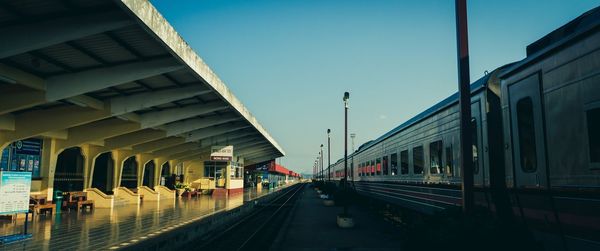 Train at railroad station in city against sky