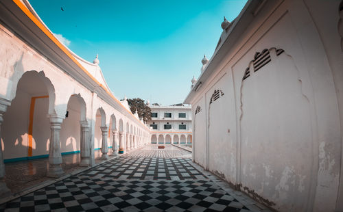 Footpath amidst buildings in city against sky