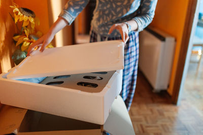 Midsection of woman holding table at home