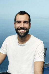 Portrait of smiling man standing against sea