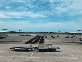 Airplane on airport runway against sky