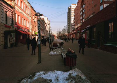 People walking on street amidst buildings in city