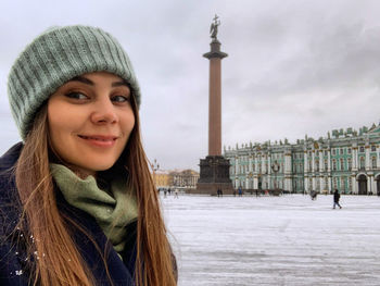 Portrait of young woman with alexander column and winter palace in background