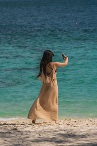 Rear view of woman standing on beach