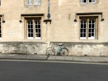 Man cycling on bicycle against building in city