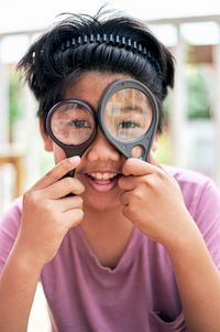 Portrait of smiling young woman holding eyeglasses