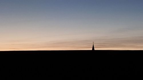 Silhouette landscape against sky at sunset