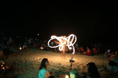 Group of people against sky at night