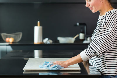 Woman cleaning the table while cooking at the modern kitchen