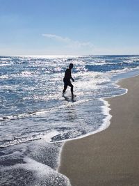 People on beach by sea against sky