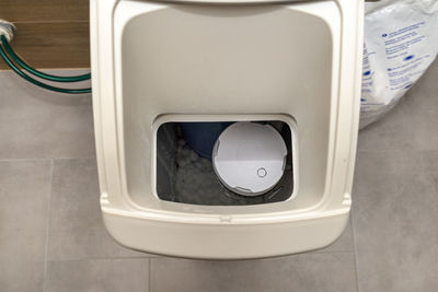 Homemade water softener standing in the boiler room with the lid open.