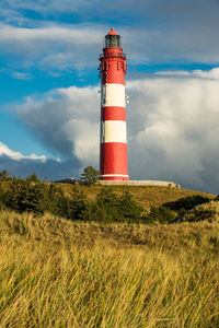 Low angle view of lighthouse on field against sky