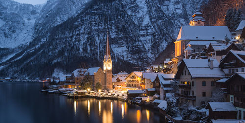 Buildings by lake during winter in hallstatt at dusk