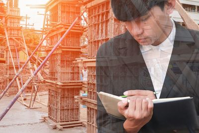 Double exposure of businessman and construction site