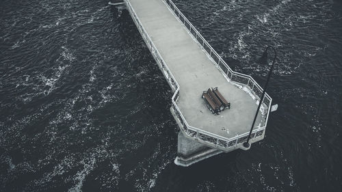 Desaturated view of walking pier from above with benches and light. windy cold day during winter