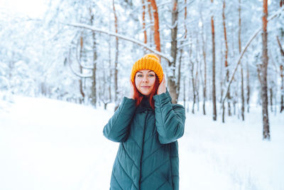 Young beautiful woman in winter forest with fir trees person