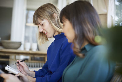 Side view of female partners communicating in store