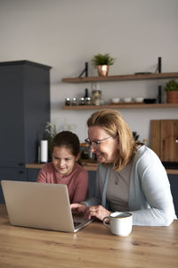 Friends using laptop at table