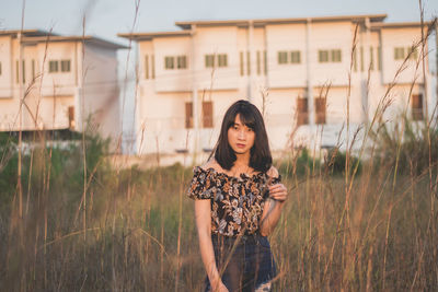 Portrait of young woman standing on field