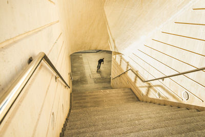 Rear view of young man riding bicycle on steps