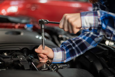 Midsection of man repairing car