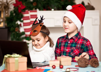 Cute sibling looking at laptop during christmas