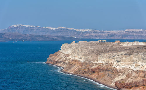 Scenic view of sea and mountains against blue sky