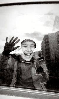 Portrait of smiling boy on glass window