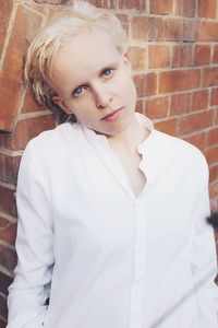 Portrait of cute girl standing against wall